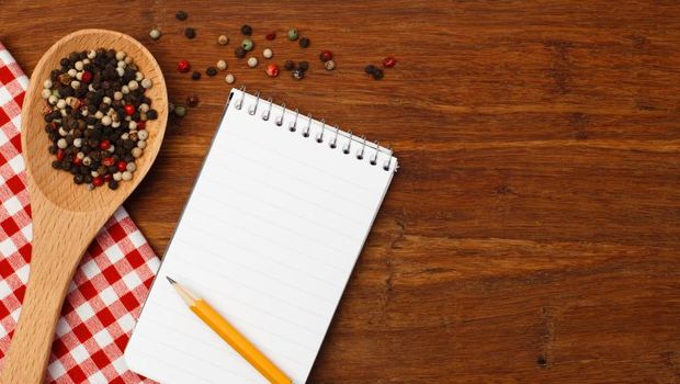 Note book with pencil on cutting board
