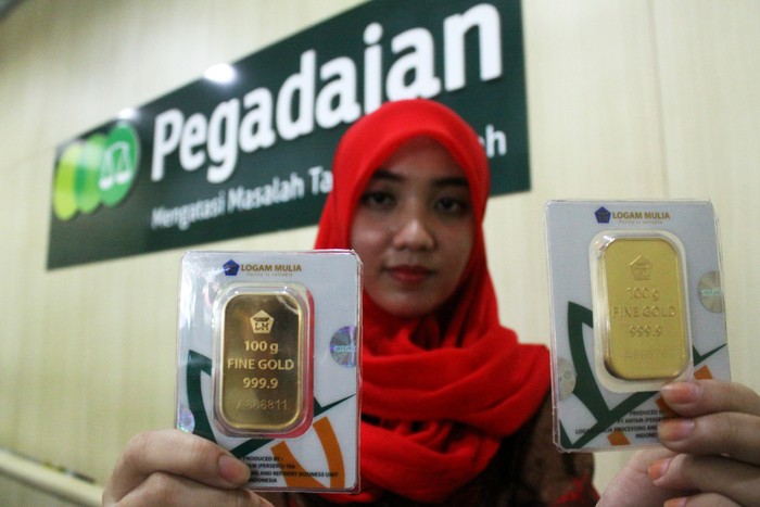 Pekerja memperlihatkan emas batangan yang digadaikan di Kantor Pegadaian Bekasi, Kota Bekasi, Jawa Barat, Rabu (1/6). Jumlah transaksi gadai emas dan barang di pegadaian area tersebut meningkat sekitar dua persen karena mulai banyak masyarakat yang ingin membuka usaha pakaian dan makanan serta membeli kebutuhan menjelang bulan Ramadan. ANTARA FOTO/Risky Andrianto/foc/16.