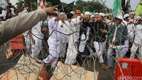 Pengunjukrasa berusaha menerobos pagar kawat berduri namun dihadang polisi.