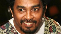 Glenn terlihat mengenakan top fedora dengan vest batik serta kaus putih. Pool/Gus Mun/detikFoto.