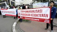 Demonstran membawa spanduk bertuliskan Stop Komersialisasi Pendidikan Kedokteran dan Berlakukan Moratorium FK.