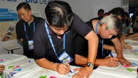 Mantan atlet bulutangkis nasional Alan Budikusuma dan Christian Hadinata menandatangani jersey.