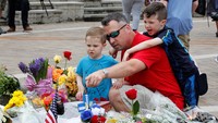 Todd Fortwengler dan anaknya meletakan karangan bunga di Ali Center, Louisville, Kentucky. REUTERS/John Sommers II.