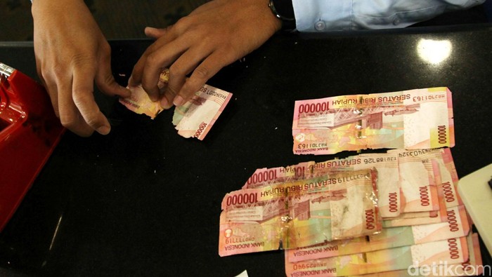 Petugas mengecek kondisi uang rusak yang ditukarkan oleh warga di Bank Indonesia, Jakarta, Senin (6/6). BI meminta masyarakat agar menukarkan uang yang sudah tidak layar edar dengan uang baru sehingga uang yang beredar di masyarakat berkualitas tinggi dengan syarat, uang asli, masih tersisa minimal 2/3 bagian dari bentuk uang tersebut dan masih terdapat nomor seri. Agung Pambudhy/detikcom.