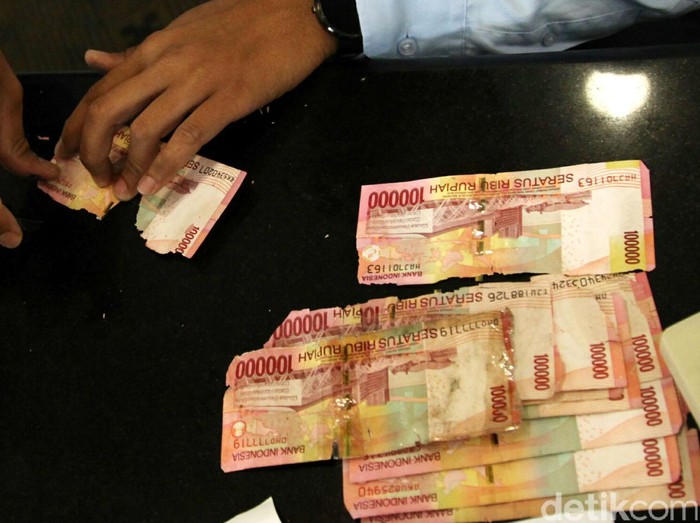 Petugas mengecek kondisi uang rusak yang ditukarkan oleh warga di Bank Indonesia, Jakarta, Senin (6/6). BI meminta masyarakat agar menukarkan uang yang sudah tidak layar edar dengan uang baru sehingga uang yang beredar di masyarakat berkualitas tinggi dengan syarat, uang asli, masih tersisa minimal 2/3 bagian dari bentuk uang tersebut dan masih terdapat nomor seri. Agung Pambudhy/detikcom.