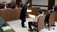 Pengacara kedua terdakwa membagikan berkas pledoi kepada hakim, jaksa dan terdakwa.