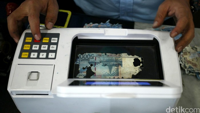 Petugas mengecek kondisi uang rusak yang ditukarkan oleh warga di Bank Indonesia, Jakarta, Senin (6/6). BI meminta masyarakat agar menukarkan uang yang sudah tidak layar edar dengan uang baru sehingga uang yang beredar di masyarakat berkualitas tinggi dengan syarat, uang asli, masih tersisa minimal 2/3 bagian dari bentuk uang tersebut dan masih terdapat nomor seri. Agung Pambudhy/detikcom.