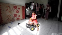 Seorang anak asyik bermain mobil-mobilan di dalam rusun.