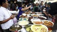 Pedagang melayani pembeli.