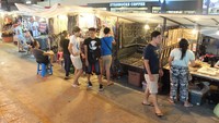Sejumlah pelancong sibuk memilih aneka aksesori pada salah satu jongko di atas trotoar. Tawar menawar harga bergulir (Baban/detikTravel)