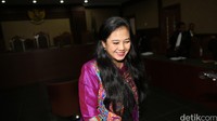 Damayanti Wisnu Putranti meninggalkan ruang sidang sambil melempar senyuman.