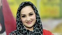 Mona menutupi kepalanya dengan kerudung kotak-kotak hitam-putih. Pool/Noel/detikFoto.