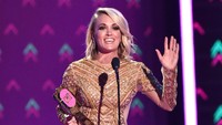 Ketika menerima penghargaan, ia pun berganti busana menjadi dress mini berwarna emas rancangan Elie Madi. Mike Coppola/Getty Images for CMT/detikFoto.