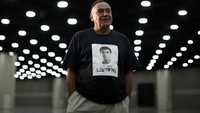 Seorang pria yang tampak memakai kaos berwarna hitam bergambar wajah Muhammad Ali tampak datang untuk ikut mensalati jenazah sang legenda. Lucy Nicholson/reuters/detikFoto.