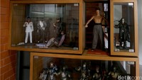 Partisi berupa rak kayu berisi action figure menjadi pemanis antara ruang tamu dan ruang tengah.