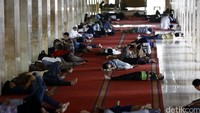 Tampak barisan warga yang beristirahat di selasar Masjid Istiqlal Jakarta. 