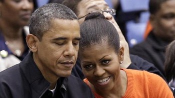 Obama pun kadang lebih memperhatikan BlackBerry kesayangannya saat duduk di samping sang istri, Michelle Obama. Foto: Yuri Gripas/Reuters