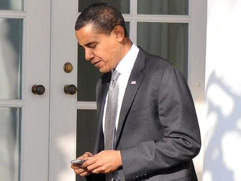 US President Barack Obama reads from his Blackberry cellphone alongside his daughters Sasha (L) and Malia (R) during a shopping trip to One More Page Books on Small Business Saturday, which promotes shopping at local small businesses, in the Falls Church neighborhood of Arlington, Virginia, on November 24, 2012. AFP PHOTO / Saul LOEB (Photo credit should read SAUL LOEB/AFP/Getty Images)