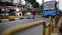 Petugas membuka portal saat bus TransJakarta melintas, Senin (13/6/2016).