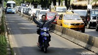 Seorang pengendara tanpa helm nekat menoros jalur Busway di Jalan Warung Buncit Raya, Jakarta Selatan, Senin (13/06/2016).