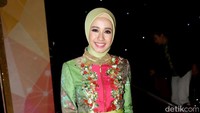 Pada kesempatan itu, ia mengenakan busana bernuansa hijau dan pink.