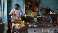 Seorang pemilik Warung Tegal (Warteg) di depan sisa-sisa perabot rumah tangga yang terbakar.