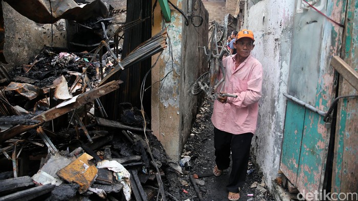 Pemulung barang bekas memunguti sisa perabot rumah tangga di lokasi kebakaran, di RT 12/10, Keagungan, Tamansari, Jakarta Barat, Selasa (14/6/2016) yang terjadi saat warga menyiapkan menu sahur Selasa dini hari.