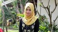 Ia tampil mengenakan hijab kuning, dress hitam bermotif floral dipadu legging hitam dan flat shoes coklat-putih. Pool/Ismail/detikFoto.