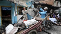 Pemulung memunguti sisa perabot rumah tangga di lokasi kebakaran, Selasa (14/6/2016)