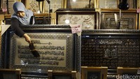 Seorang penjual membersihkan pajangan Kaligrafi yang dijual di pusat perbelanjaan di Jakarta.