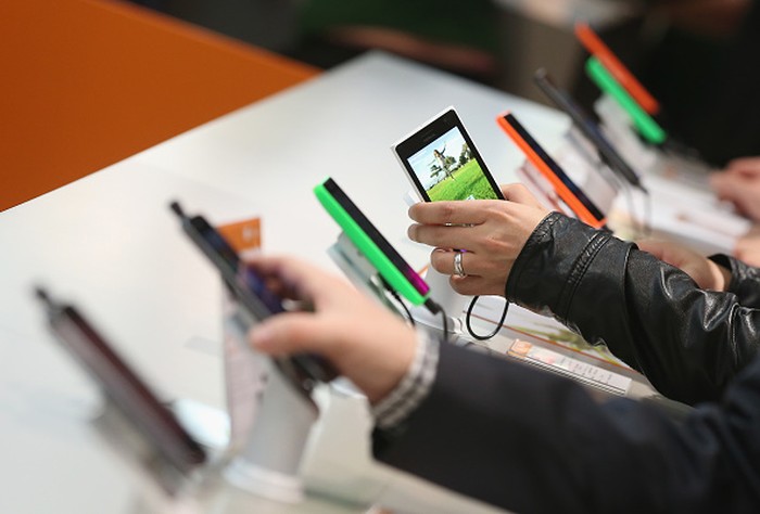 HANOVER, GERMANY - MARCH 16:  Visitors look at Windows-enabled smartphones, including the Nokia Lumia series, at the Microsoft stand the 2015 CeBIT technology trade fair on March 16, 2015 in Hanover, Germany. China is this years CeBIT partner. CeBIT is the worlds largest tech fair and will be open from March 16 through March 20.  (Photo by Sean Gallup/Getty Images)
