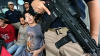 Para tersangka dihadirkan dengan penjagaan petugas bersenjata api laras panjang.