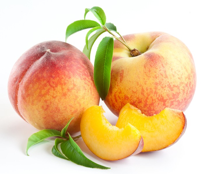 Buah segar Ripe peach fruit with leaves and slises on white background.