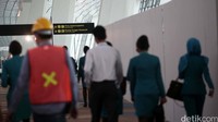 Para pekerja tengah berjalan di dalam Terminal Ultimate 3.
