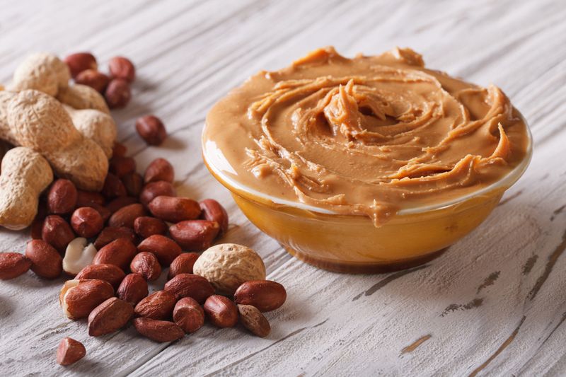 Tasty peanut butter in a bowl close up on the table. horizontal