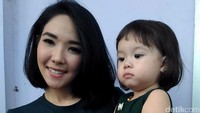 Gempi tampak cute dibalut dress hijau dan sepatu putih.
