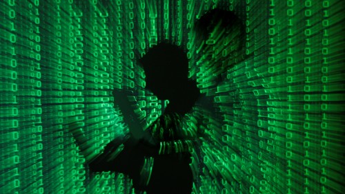 An illustration picture shows a projection of binary code on a man holding a laptop computer, in an office in Warsaw June 24, 2013. REUTERS/Kacper Pempel/Illustration/File Photo