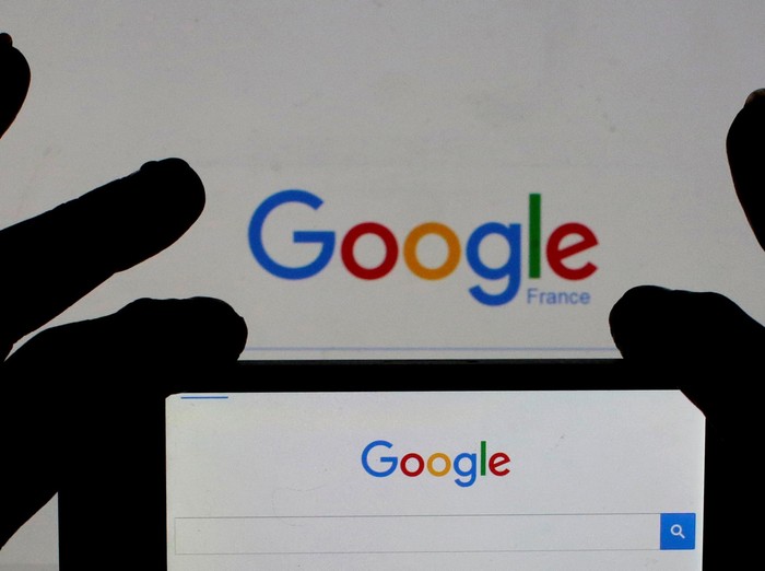 A woman holds her smart phone which displays the Google home page, in this picture illustration taken February 24, 2016. A U.S. Jury handed Google a major victory May 26, 2016 in a long-running copyright battle with Oracle Corp over Android software to run most of the worlds smartphones.  REUTERS/Eric Gaillard/Illustration/Files     TPX IMAGES OF THE DAY