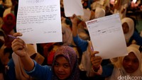 Ribuan anak yatim dan duafa memperlihatkan surat yang ditulis untuk Presiden RI.