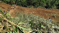 Warga melintasi lokasi longsoran karena telah memutus jalan yang menghubungkan beberapa desa di Kecamatan Loano dan Kecamatan Purworejo.