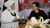 Ketua Umum Yayasan Pendidikan Soekarno (YPS) Rachmawati Soekarnoputri (kanan) memberikan potongan tumpeng kepada politisi Lily Wahid (kiri).