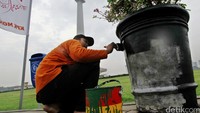 Satu per satu pot bunga di kawasan Monas dicat ulang dengan warna hitam.