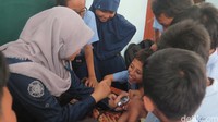 Evaluasi dilakukan dengan membagi kelas menjadi tiga kelompok. Masing-masing kelompok akan di-rolling ke tiga pos yang berbeda. Pos pertama adalah pos pengenalan obat modern seperti tablet, kapsul, sirup, inhaler dan injeksi. Belum sempat ditanya, para siswa sudah bisa menjelaskan masing-masing jenis obat tersebut. (Foto: Rahma Lillahi S/detikHealth)