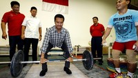 Imam Nahrawi menghimpun tenaga untuk mengangkat barbel yang biasa digunakan para atlet latihan.