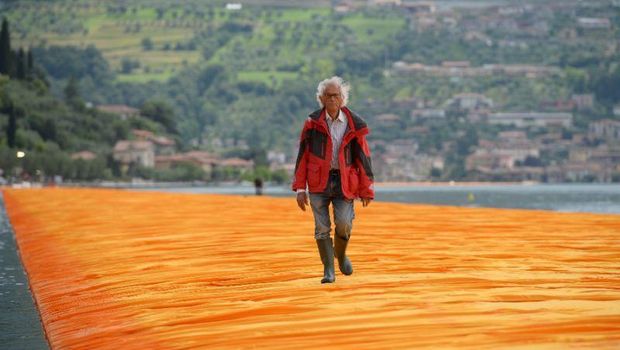 People walk on the monumental installation entitled 'The Floating Piers' created by artist Christo Vladimirov Javacheff on Iseo Lake, in northern Italy, on June 18, 2016.Some 200,000 floating cubes create a 3-kilometers runway connecting the village of Sulzano to the small island of Monte Isola on the Iseo Lake for a 16-day outdoor installation opening today. / AFP / MARCO BERTORELLO / RESTRICTED TO EDITORIAL USE - MANDATORY MENTION OF THE ARTIST UPON PUBLICATION - TO ILLUSTRATE THE EVENT AS SPECIFIED IN THE CAPTION        (Photo credit should read MARCO BERTORELLO/AFP/Getty Images)
