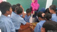 Di pos ketiga, mahasiswa yang tergabung dalam Piogama (Pusat Informasi Obat memperkenalkan alat pengukur tekanan darah berikut stetoskopnya. Satu dua anak mengaku pernah memeriksa tekanan darah dengan alat mereka, namun yang paling membuat mereka antusias adalah mencoba mendengar detak jantung lewat stetoskop. (Foto: Rahma Lillahi S/detikHealth)