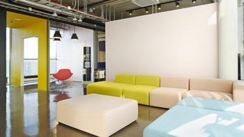 Terdapat sofa panjang dengan beragam warna, tampak sinar matahari masuk menyinari dalam ruang kerja. Foto: koko3.fi