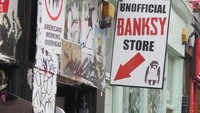 Yang unik di Portobello Market adalah toko suvenir bertema Banksy, seniman graffiti yang identitasnya misterius. Ada banyak T Shirt dan poster dengan gambar-gambar graffiti Banksy (Fitraya/detikTravel)