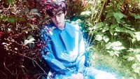 Dalam fotonya, Sehun tampak seperti tengah tertidur di sebuah kebun dengan busana biru. (Hang Jong Chul/W Korea)