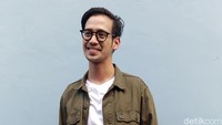 Ia tampak mengenakan parka hijau, kaus putih dan celana cargo berwarna biru.